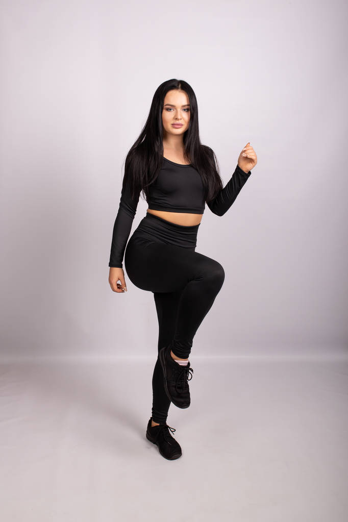 Sportieve vrouw dragen zwarte legging en terug naar boven - Foto, afbeelding