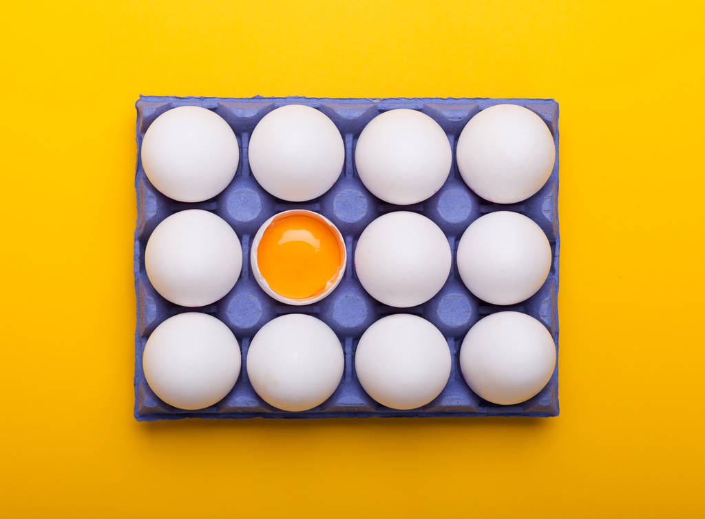 Vaječný bílek a žloutek v poli modré na žlutém podkladu - Fotografie, Obrázek