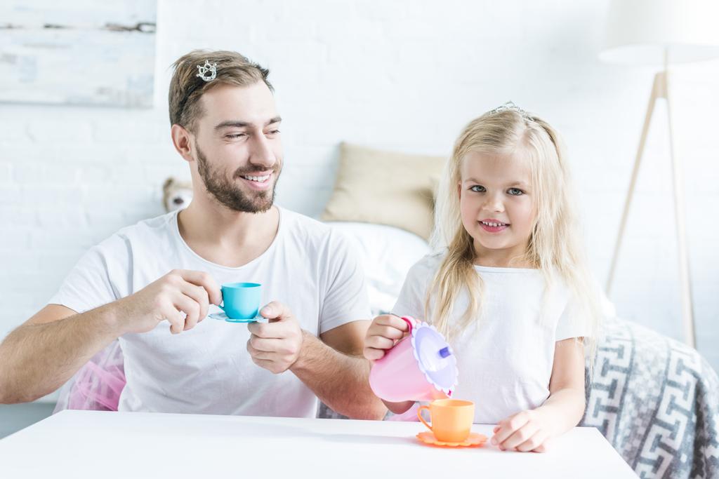 feliz padre e hija jugando juntos y fingiendo tener una fiesta de té
 - Foto, imagen