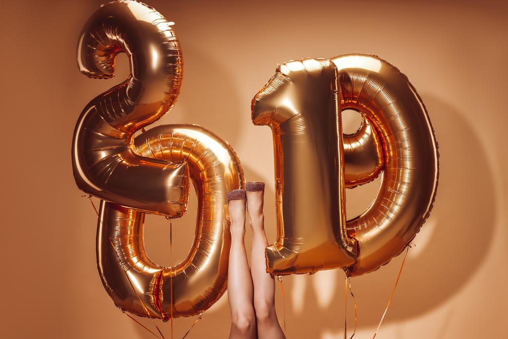 περικομμένη εικόνα γυναίκα ξαπλωμένη κάτω μπαλόνια με αριθμούς 2019 στο κόμμα σε μπεζ, νέο έτος έννοια - Φωτογραφία, εικόνα