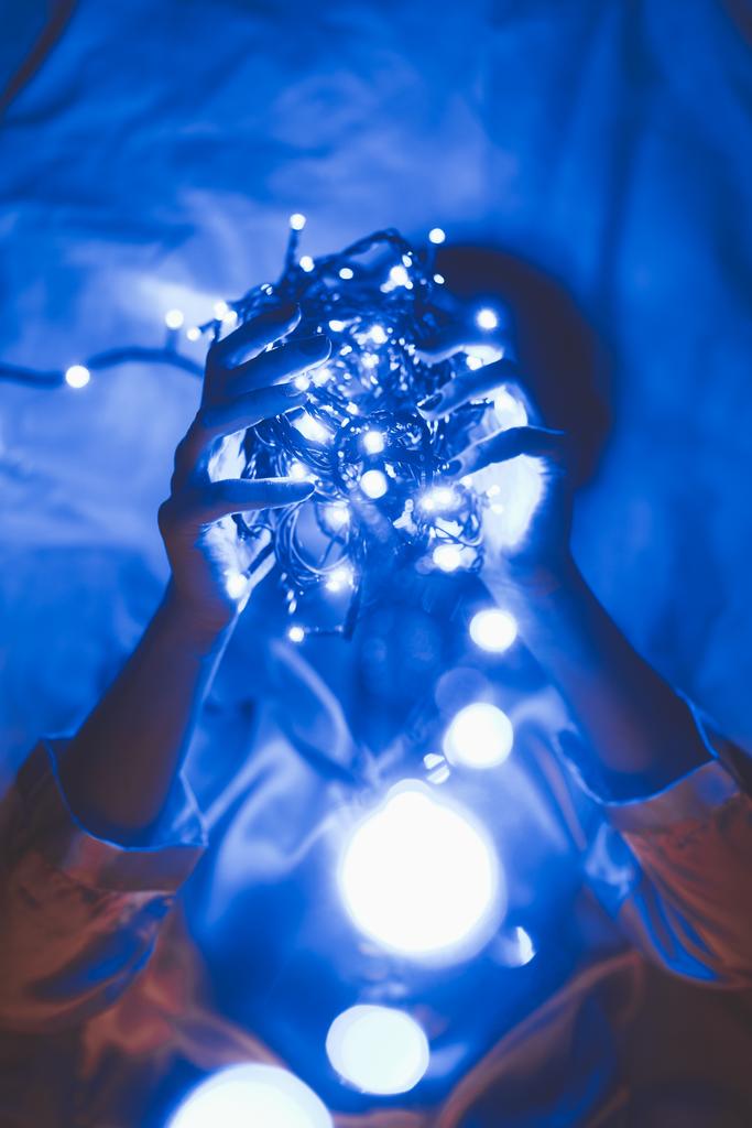 mavi ışıklar yatakta yatıyordu süre elinde tutan kadının gizlenmiş görünümü  - Fotoğraf, Görsel