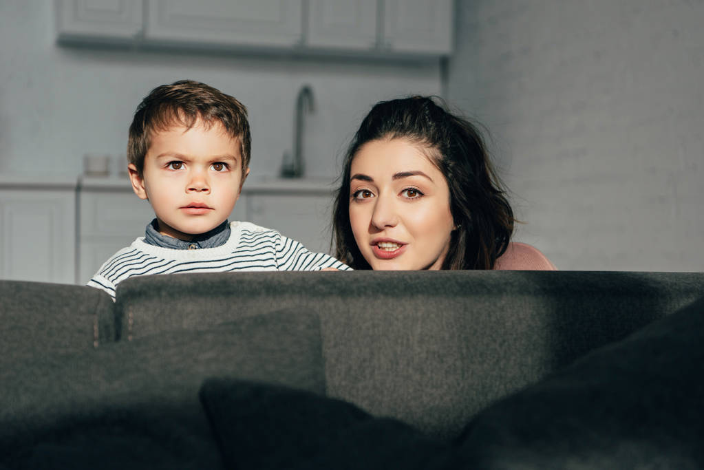 portrait of mother and little son sitting on sofa at home - Photo, Image