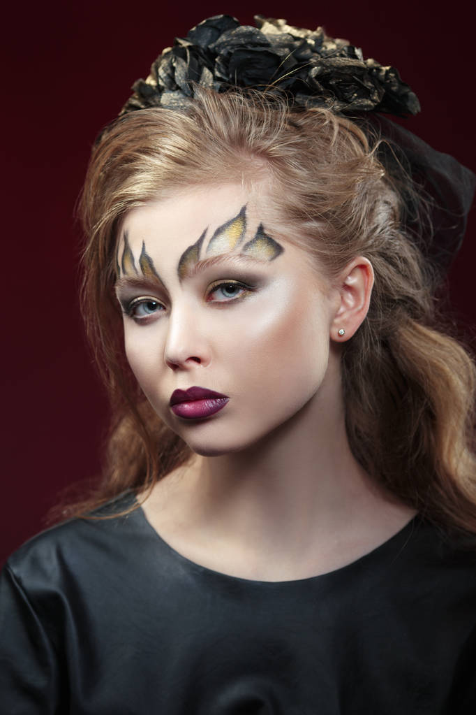 portrét atraktivní mladé ženy s luxusní make-up při pohledu na fotoaparát na tmavém pozadí - Fotografie, Obrázek