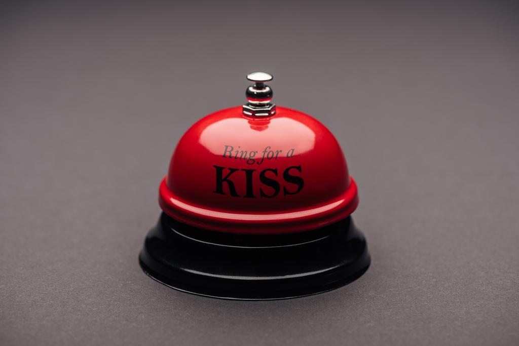 close up of red service bell with "ring for a kiss" lettering isolated on grey - Photo, Image