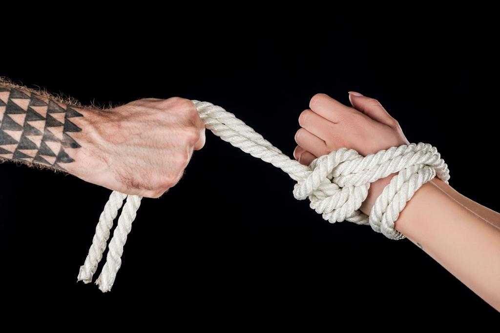 обрезанный вид доминирующей веревки на покорных руках, изолированных на черном
 - Фото, изображение