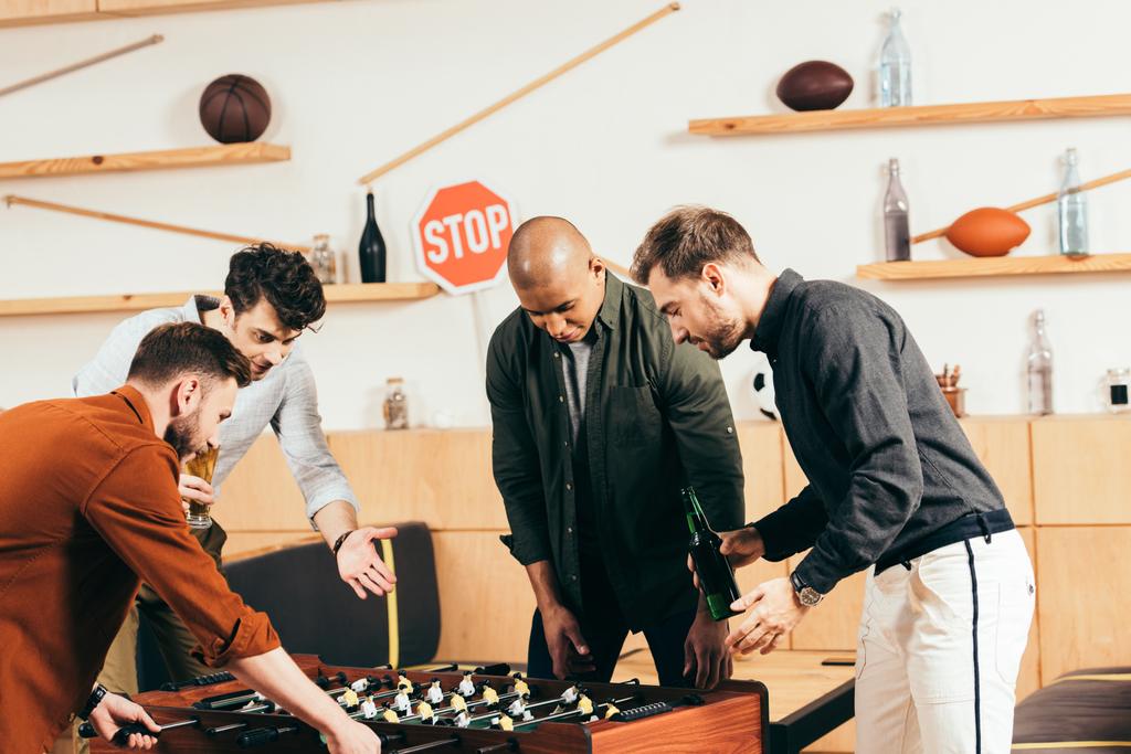multiracial young friends playing table football together in cafe - Photo, Image