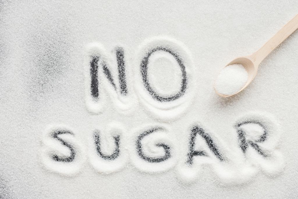"sin azúcar "letras escritas en azúcar granulada con cuchara de madera
 - Foto, imagen