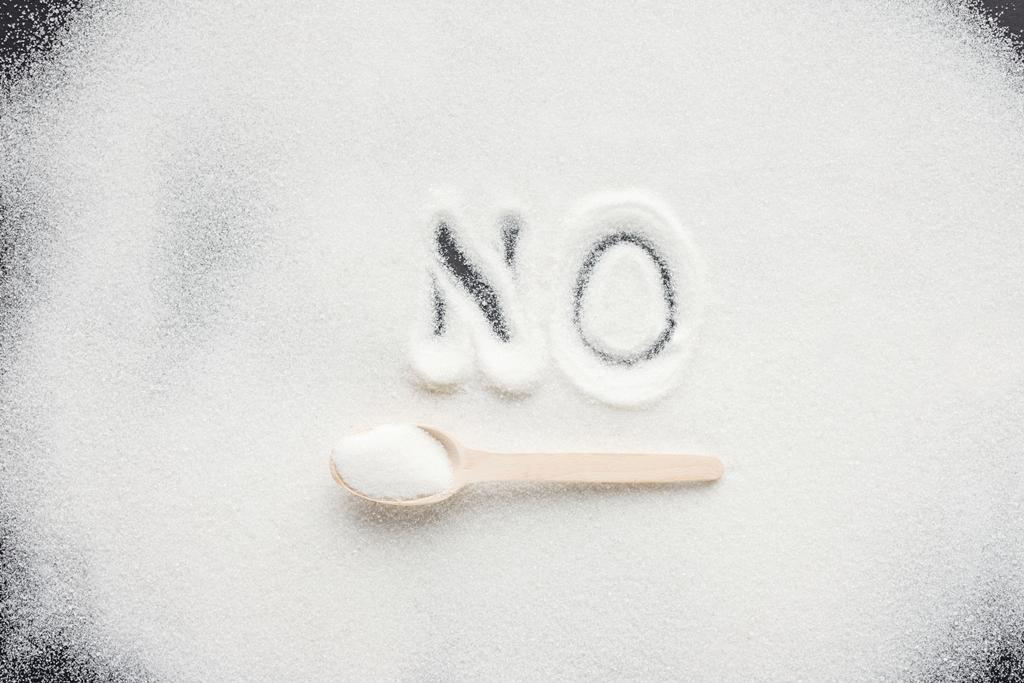 vista dall'alto della parola scritta a mano "no" sullo zucchero semolato con cucchiaio di legno
 - Foto, immagini
