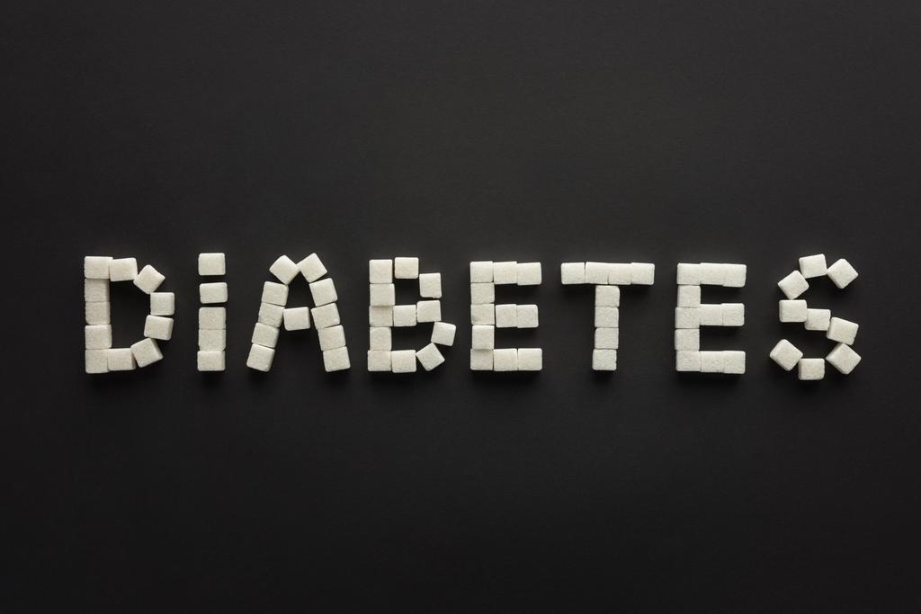 vista superior de la inscripción "diabetes" hecha de terrones de azúcar en negro
 - Foto, Imagen
