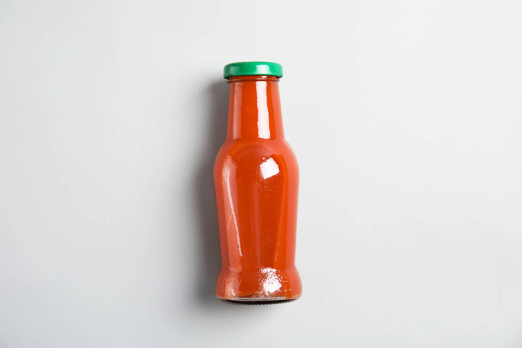 Una botella con sabrosa bebida sobre fondo de color, vista superior
 - Foto, imagen