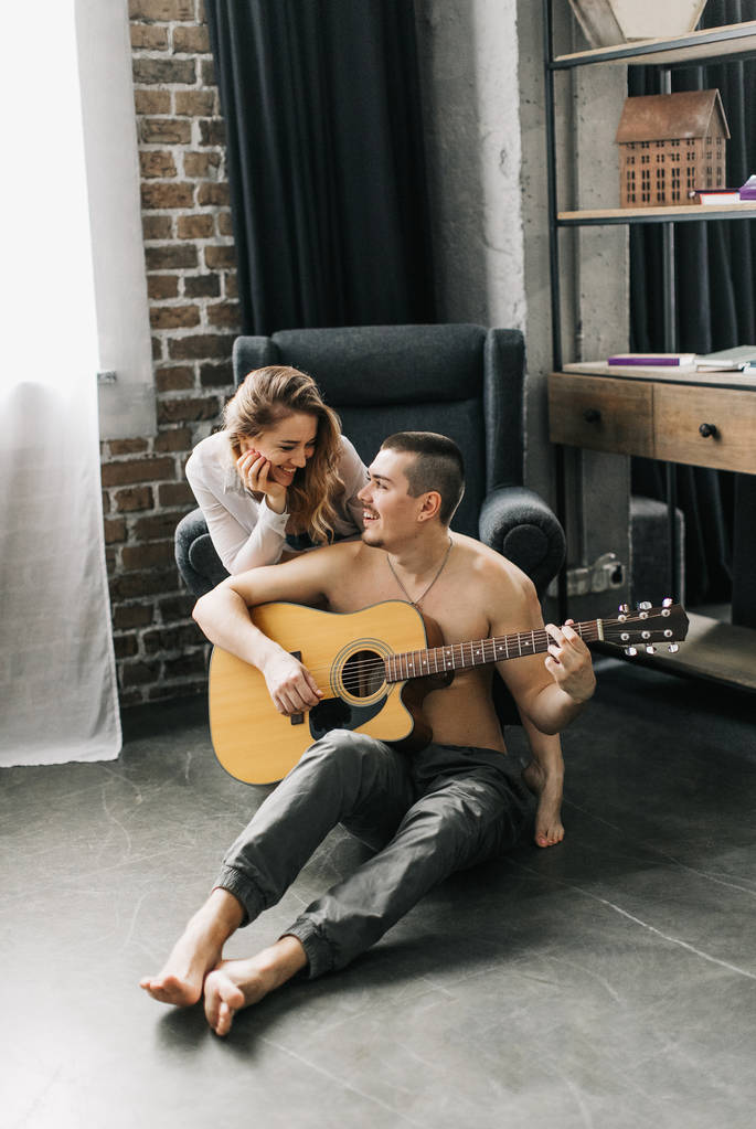 Belo casal passa tempo juntos, toca guitarra, se divertindo
 - Foto, Imagem