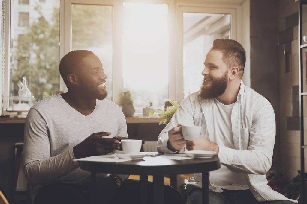Empresa multiétnica de hombres se comunica en un café
 - Foto, imagen