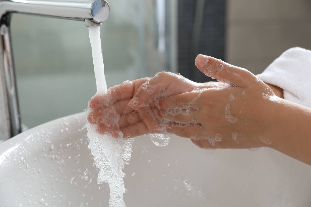 Niño pequeño lavándose las manos con jabón sobre el lavabo en el baño, primer plano
 - Foto, imagen