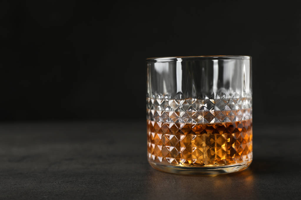 Whisky dorado en vaso con cubitos de hielo en la mesa. Espacio para texto
 - Foto, Imagen