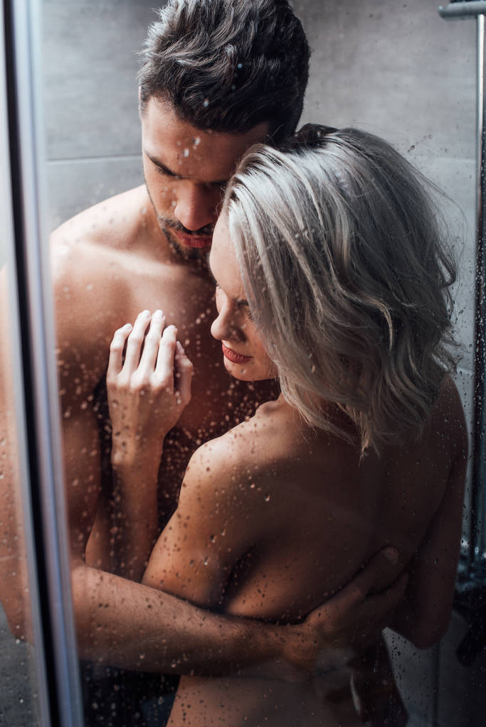 schönes nacktes Paar, das sich leidenschaftlich umarmt und zusammen duscht - Foto, Bild