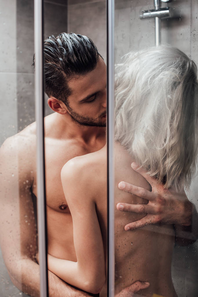 gyönyörű meztelen pár átölelve és megcsókolta a szenvedély, míg zuhanyozás együtt - Fotó, kép
