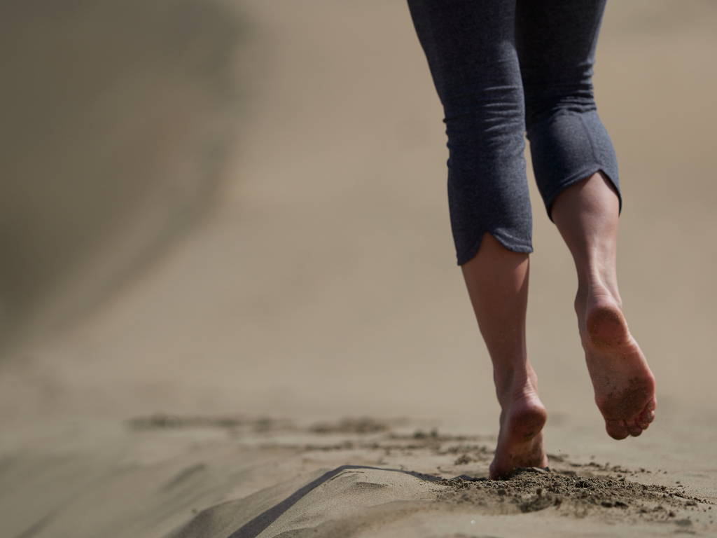bosé nohy mladé ženy běh/chůze na pláži při západu slunce - Fotografie, Obrázek