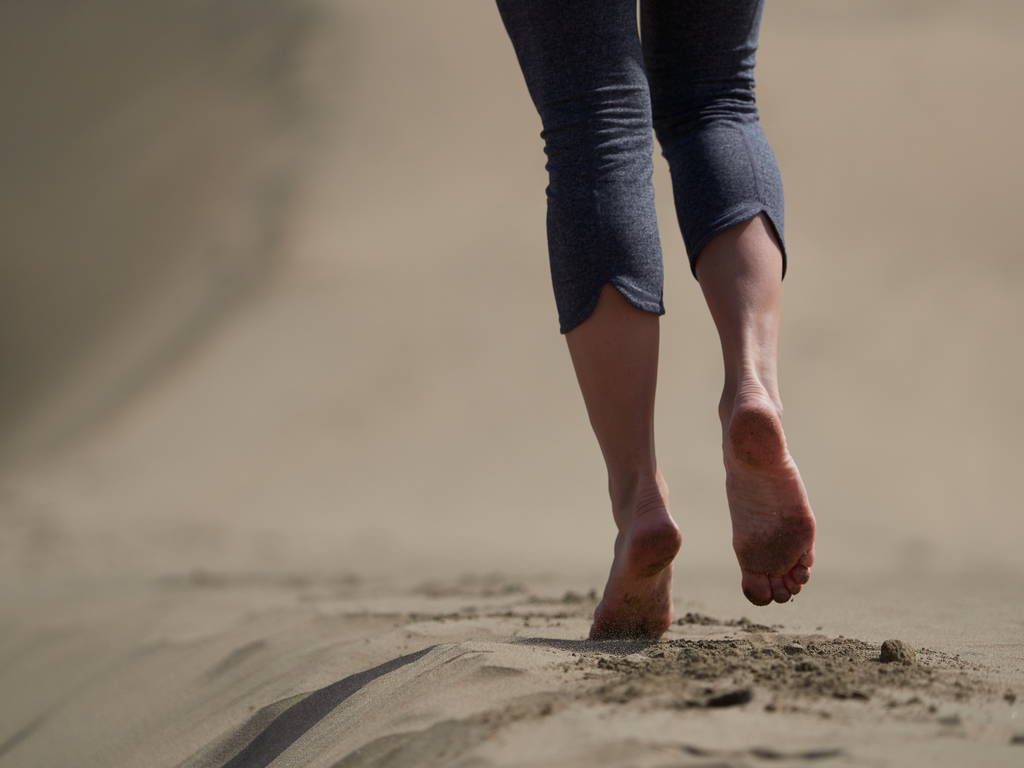 γυμνά πόδια νεαρής γυναίκας τρέξιμο/περπάτημα στην παραλία με την Ανατολή - Φωτογραφία, εικόνα
