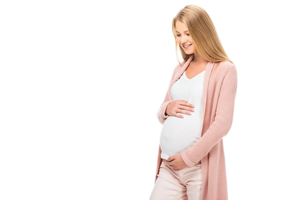 sonriente embarazada tocando vientre y mirando hacia abajo aislado en blanco
 - Foto, imagen