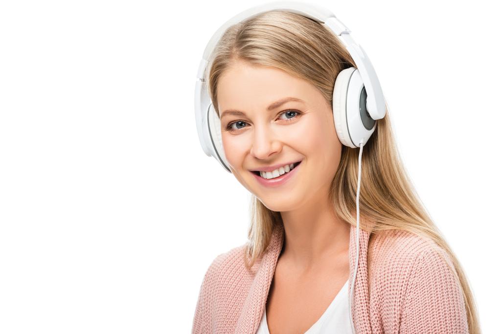 lächelnde Frau, die Musik hört, Kopfhörer benutzt und isoliert auf weiße Kamera schaut - Foto, Bild