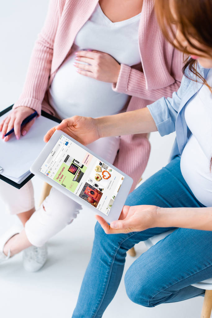 hamile kadın dijital tablet vasıl ebay uygulaması ile Doğum öncesi sınıf sırasında ekranda arıyor görünümünü kırpılmış - Fotoğraf, Görsel