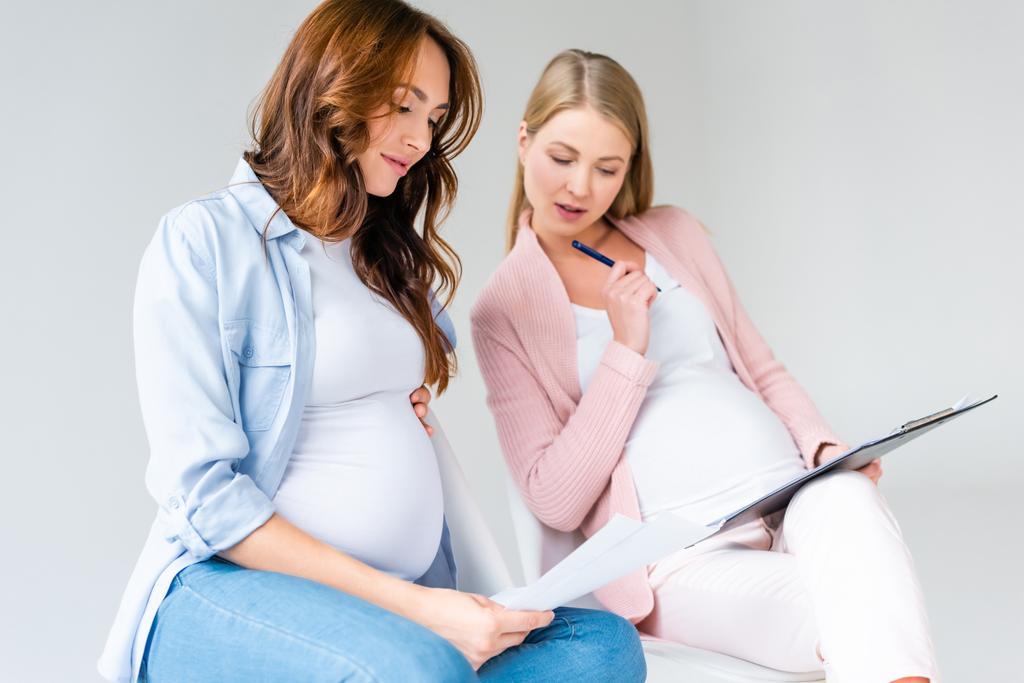 беременные женщины, разговаривающие во время дородового класса изолированные от серого
 - Фото, изображение