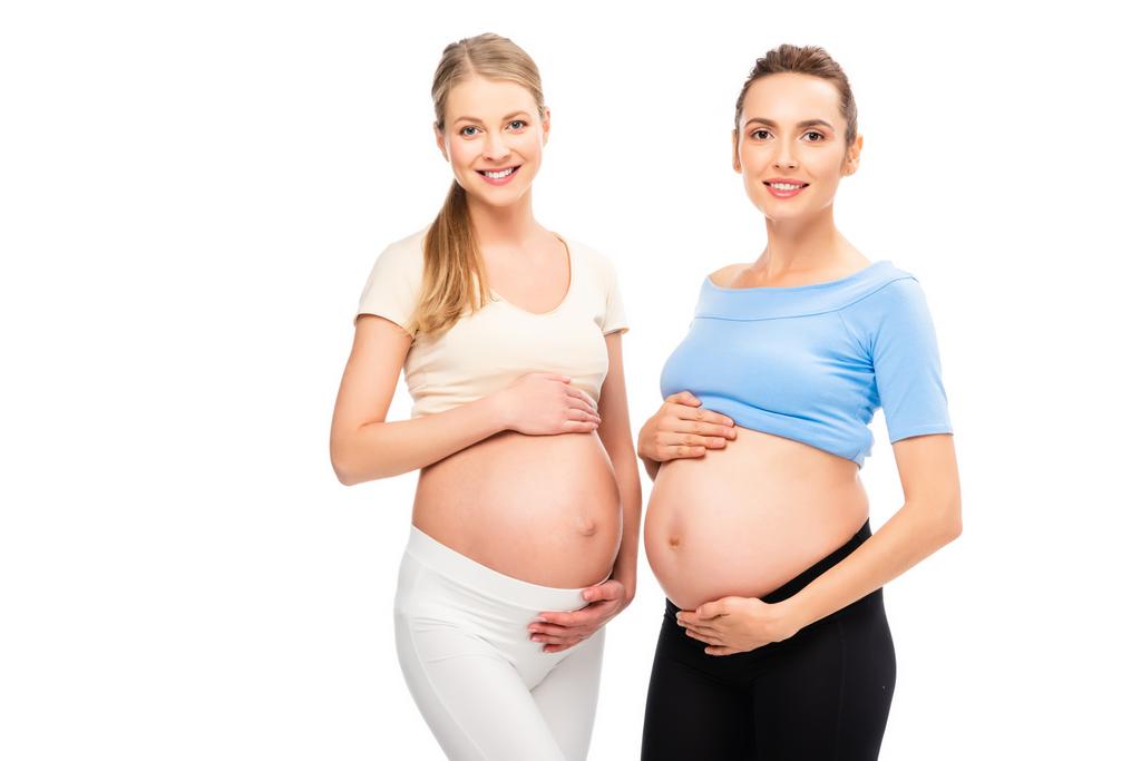 dwie kobiety w ciąży, Wyświetlono brzuchy zwrócił się do siebie na białym tle - Zdjęcie, obraz