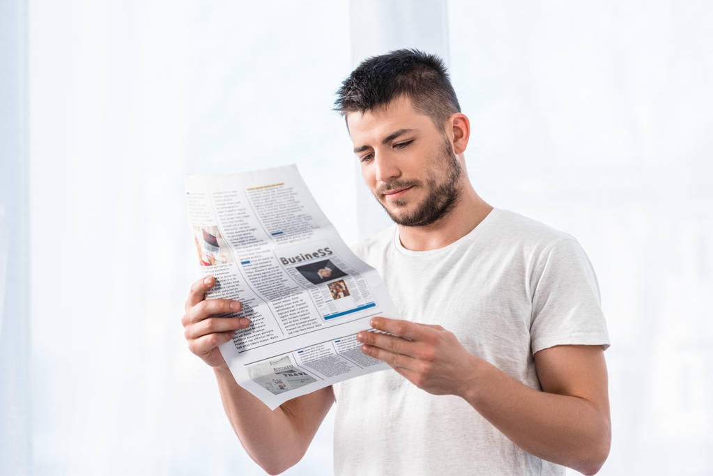 handsome man reading business newspaper in bedroom in morning at home - Photo, Image