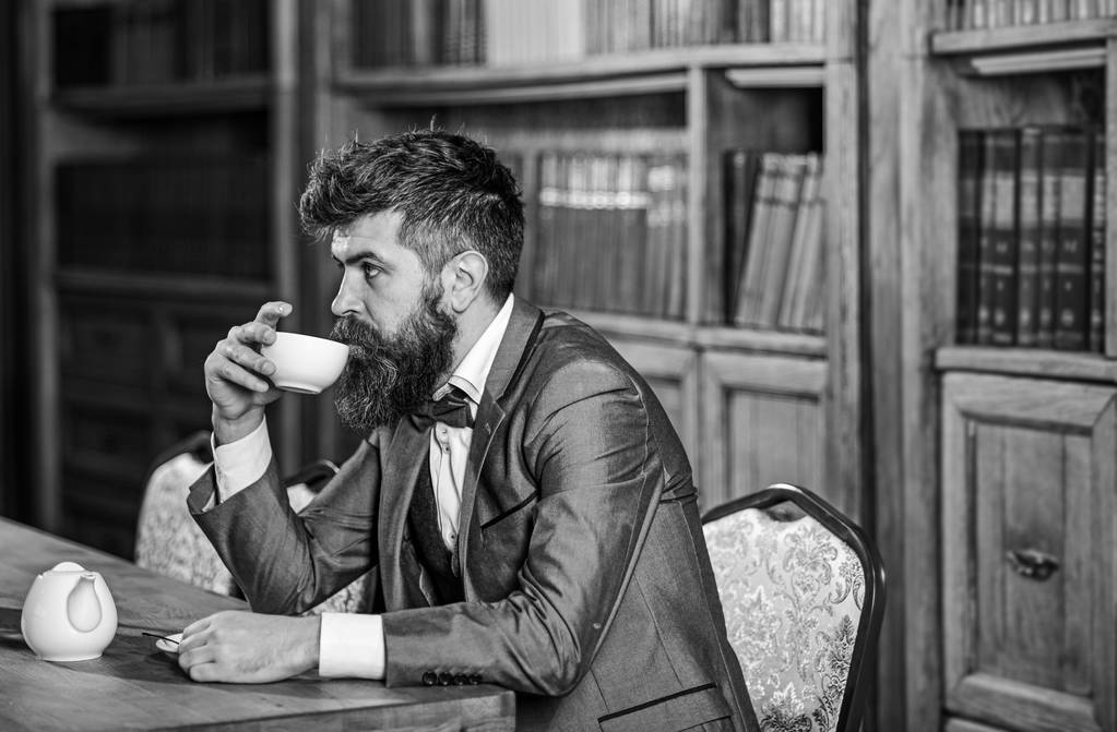 Зрелый мужчина с спокойным лицом наслаждается послеобеденным чаем
. - Фото, изображение