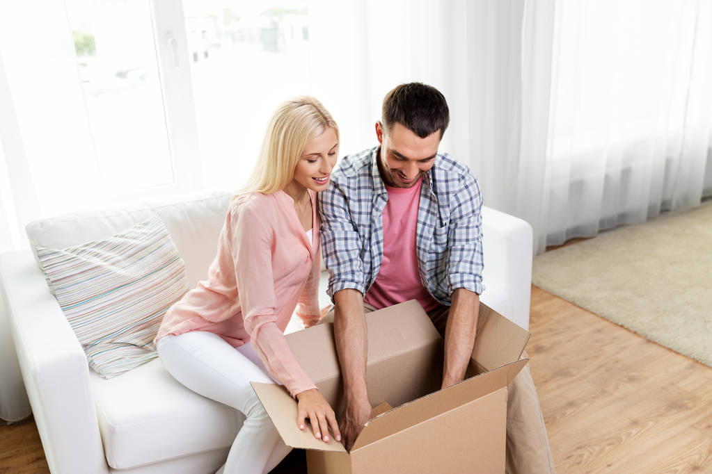 pareja feliz con caja de paquete abierta en casa
 - Foto, Imagen