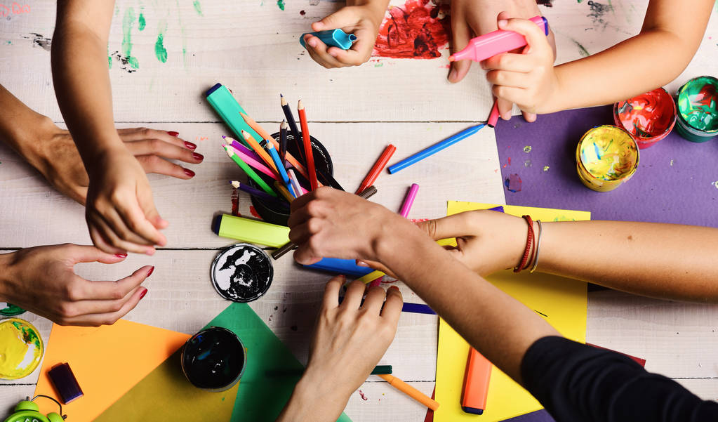 Kunstenaars handen met briefpapier en gekleurd papier. Handen houden markeringen - Foto, afbeelding