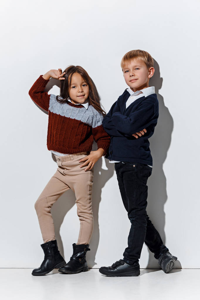 Το πορτρέτο του χαριτωμένο μικρό αγόρι και κορίτσι σε ρούχα κομψά τζιν βλέπουν φωτογραφική μηχανή στο studio - Φωτογραφία, εικόνα