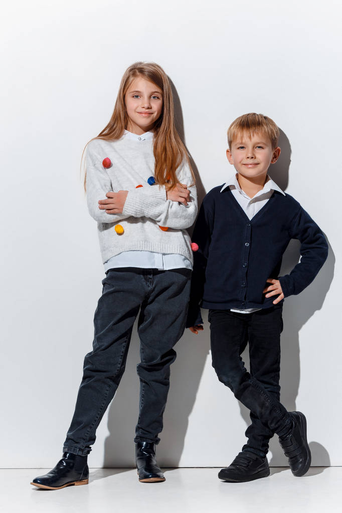 Le portrait de mignon petit garçon et fille en jeans élégants vêtements regardant la caméra au studio
 - Photo, image