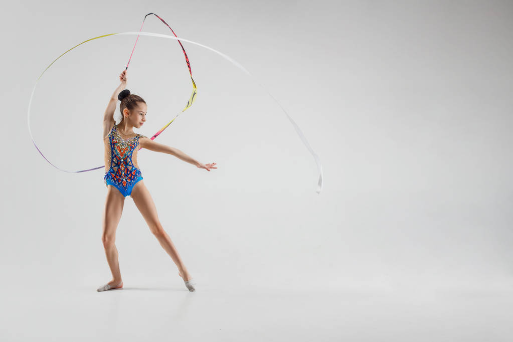 The portrait of beautiful young brunette woman gymnast training calilisthenics exercise with ribbon - Photo, Image