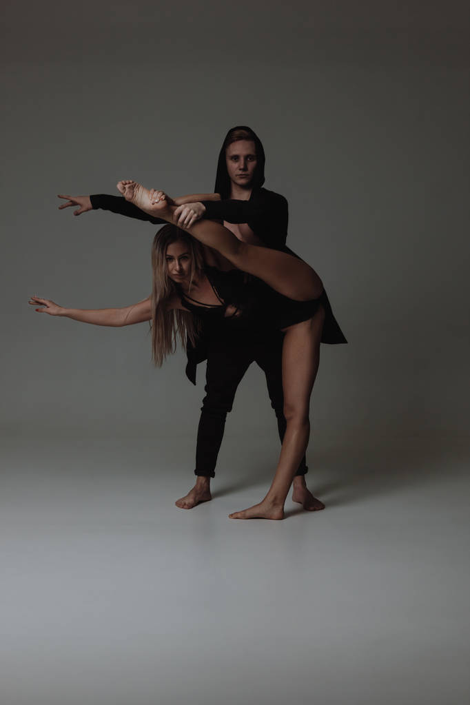 Dvě mladé moderní baletní tanečníci vystupují nad šedou studio pozadí - Fotografie, Obrázek