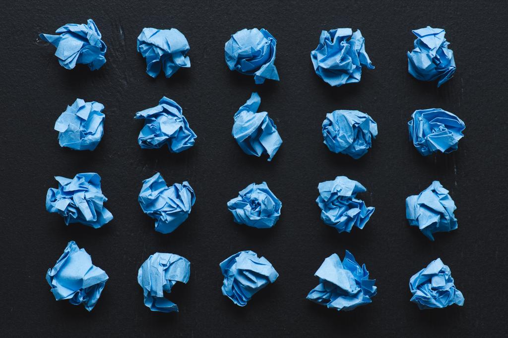 top view of blue crumpled paper balls on black background, think different concept - Photo, Image