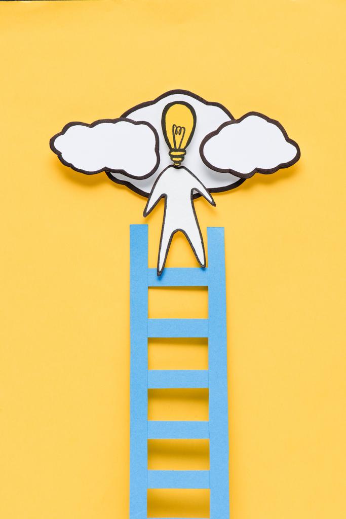 Ansicht von Pappe Mann mit Glühbirnenkopf Leiter auf gelbem Hintergrund, Ideen Konzept - Foto, Bild