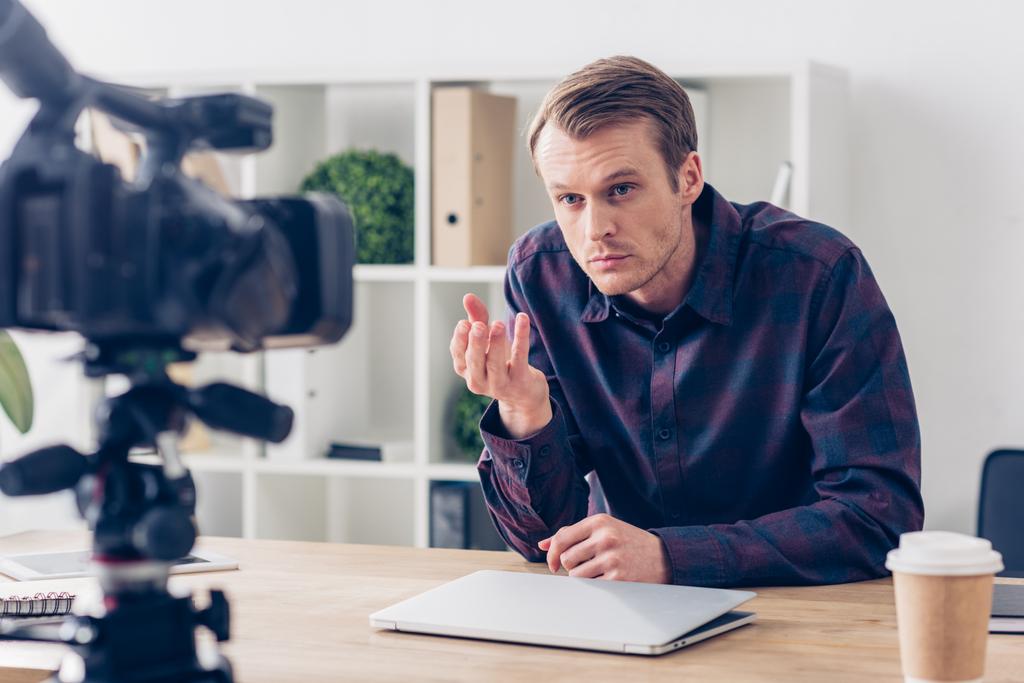 イライラして男性のビデオブロガー ビデオブログを記録し、オフィスで身振りで示す - 写真・画像