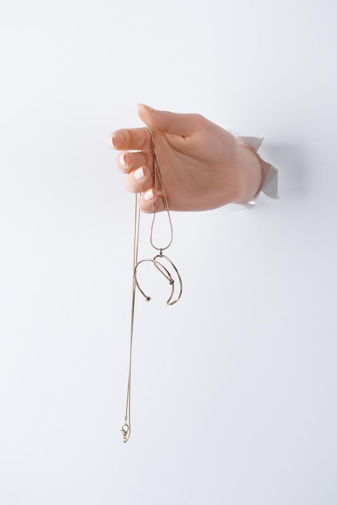 cropped image of woman holding hand with beautiful elegance necklace through white paper - Photo, Image