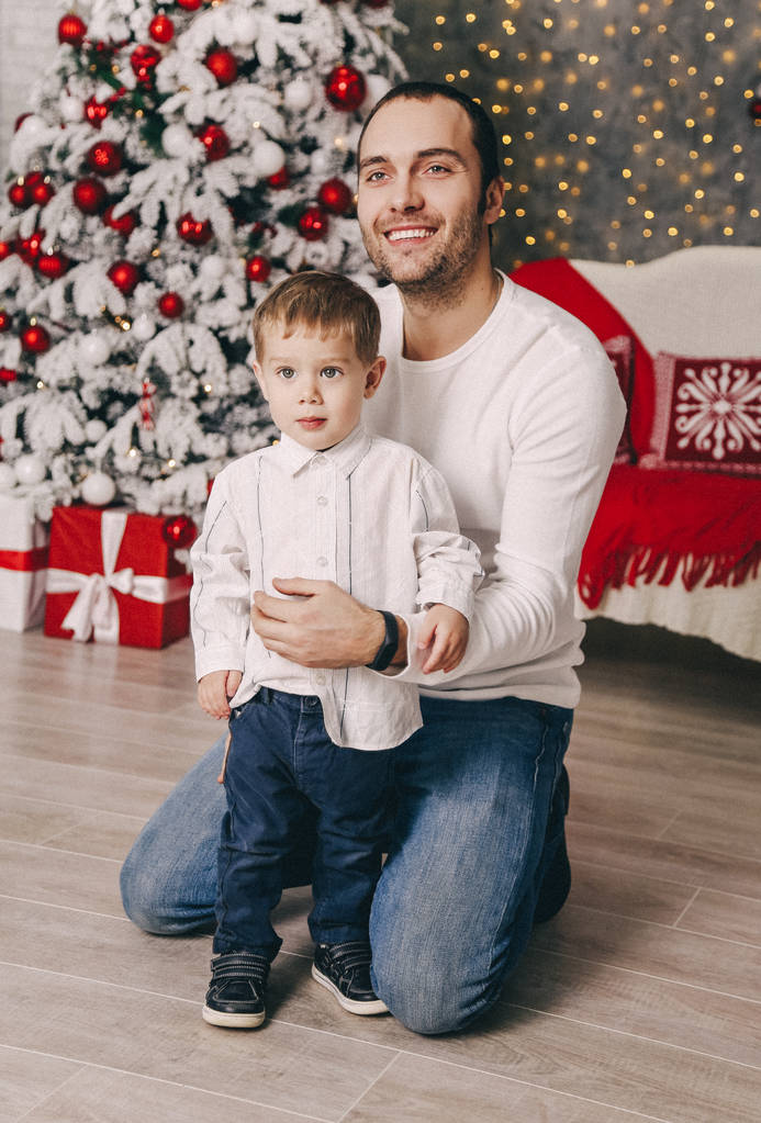 飾られた新年ツリー自宅近くかわいい小さな息子と遊んでハンサムな父の休日のクリスマスの写真 - 写真・画像