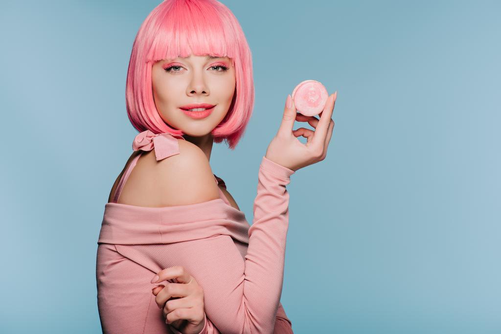 belle fille en perruque rose posant avec macaron savoureux isolé sur bleu
 - Photo, image