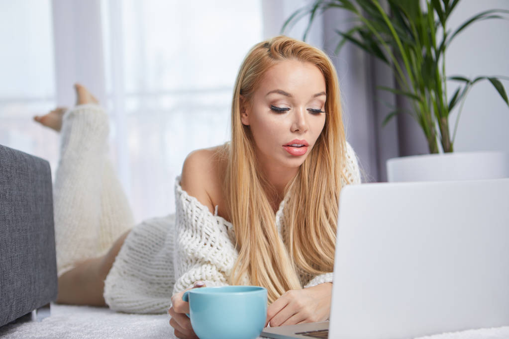 Fiatal nő használ laptop a hálószoba padlóján - Fotó, kép