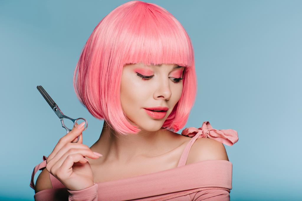 όμορφο κομψό κορίτσι στο ροζ περούκα κρατώντας ψαλίδι που απομονώνονται σε μπλε - Φωτογραφία, εικόνα