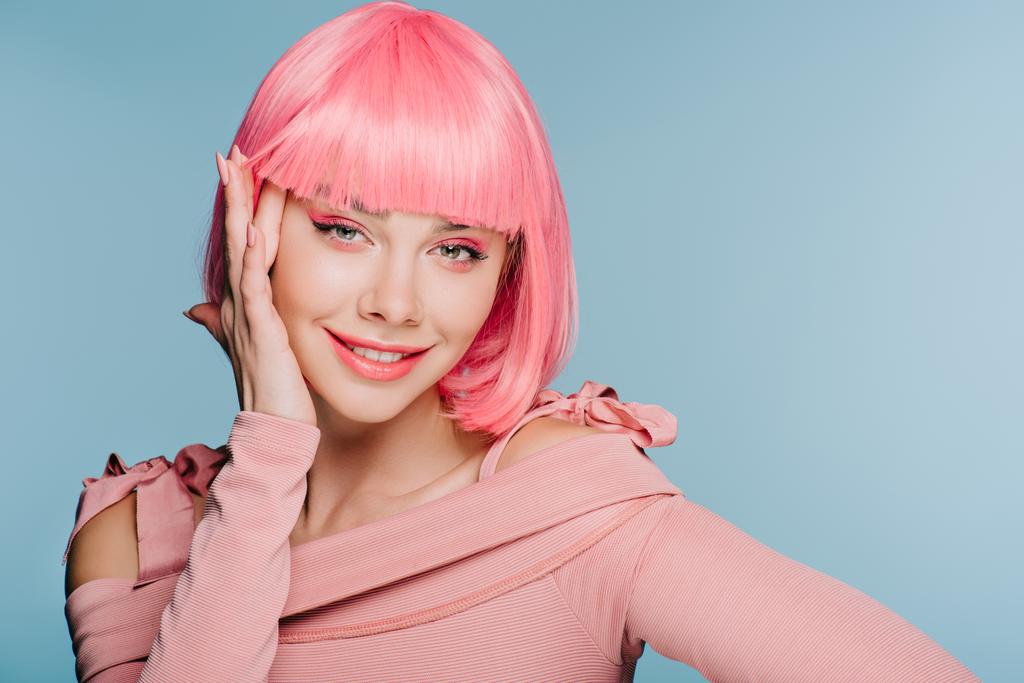 stylish smiling girl posing in pink wig isolated on blue - Photo, Image