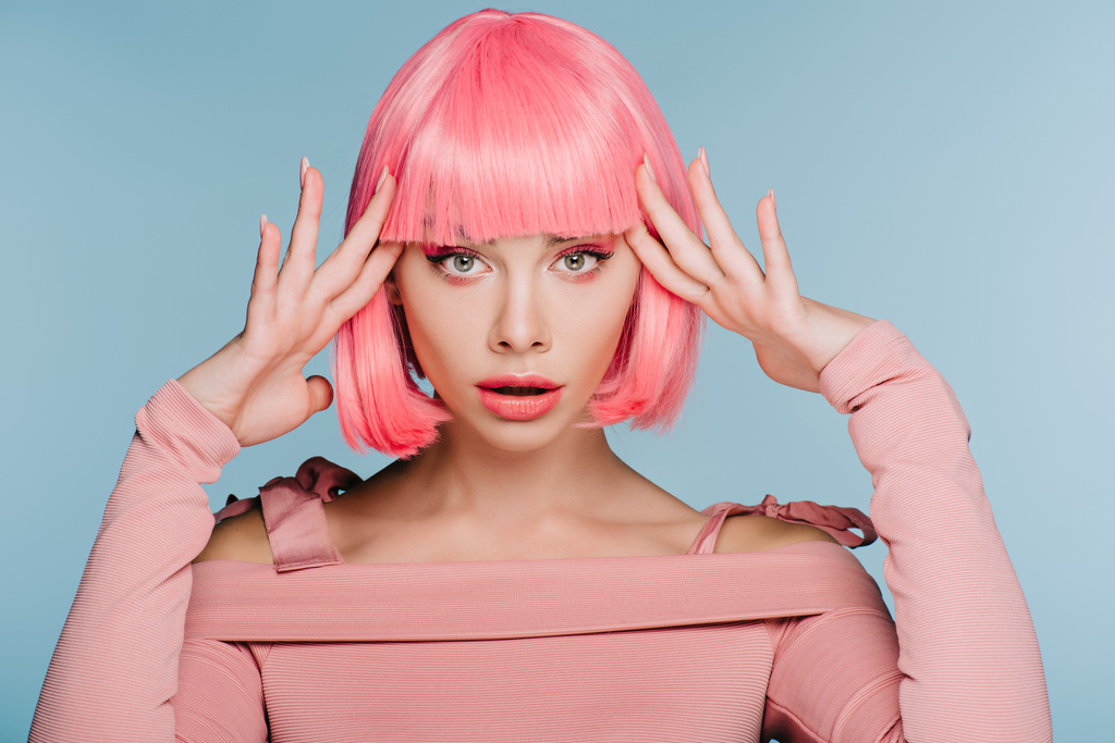 attractive shocked girl gesturing and posing in pink wig isolated on blue - Photo, Image