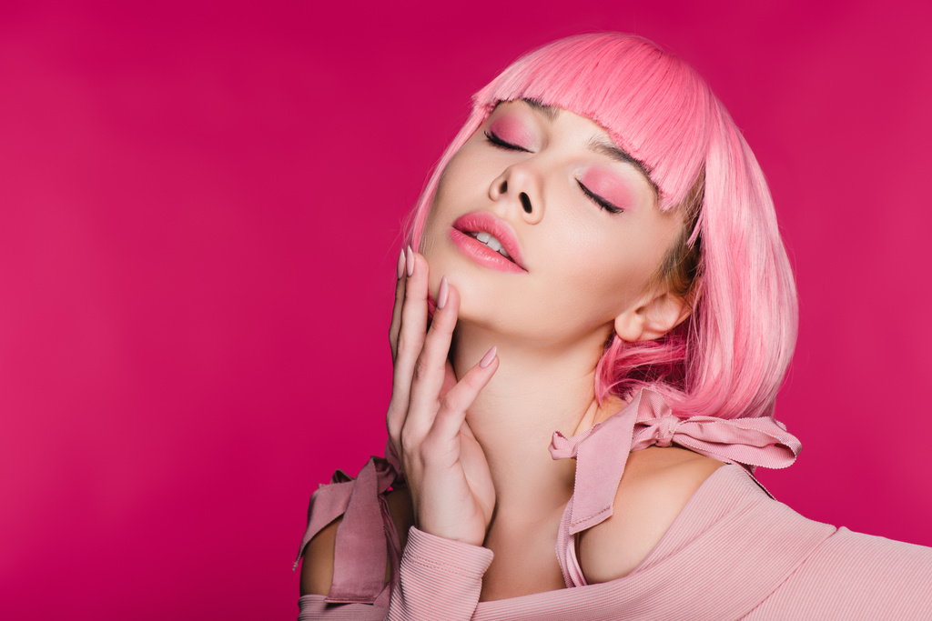 τρυφερό κομψό νεαρή γυναίκα σε ροζ περούκα ποζάρει με κλειστά τα μάτια, απομονώνονται σε ροζ - Φωτογραφία, εικόνα