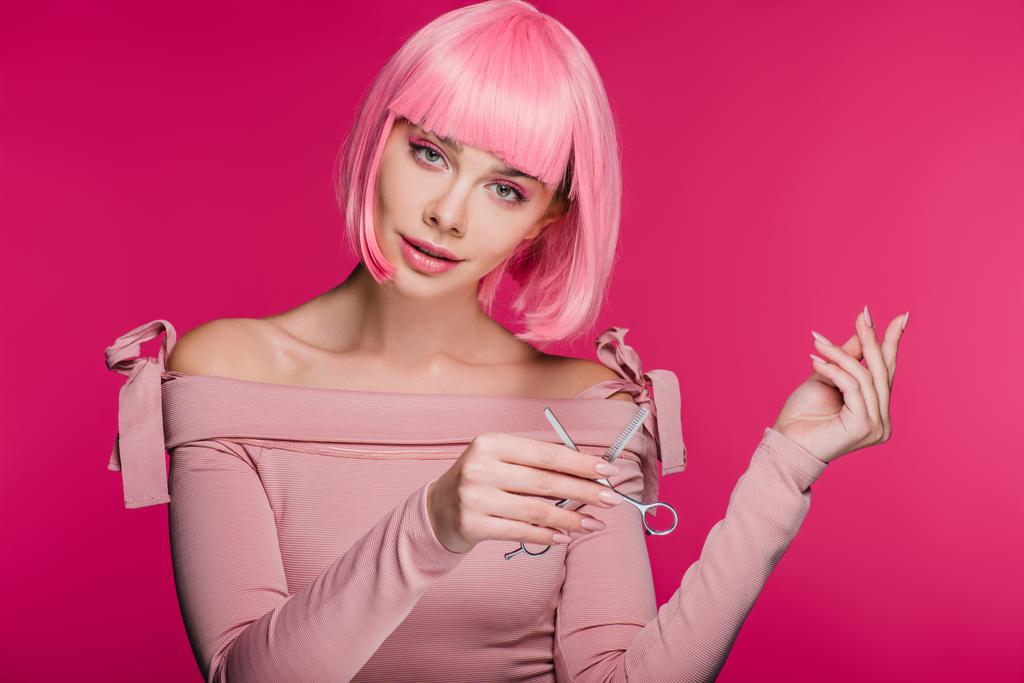 chica de moda en peluca rosa sosteniendo tijeras aisladas en rosa
 - Foto, Imagen