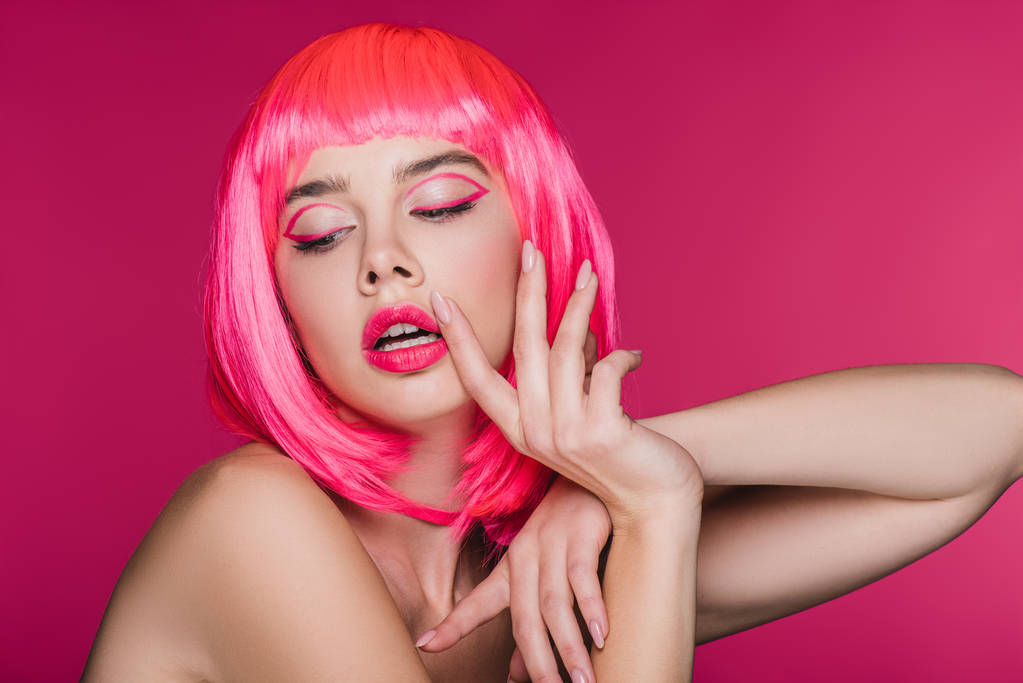 modieuze glamour model gebaren en poseren in neon roze pruik, geïsoleerd op roze - Foto, afbeelding