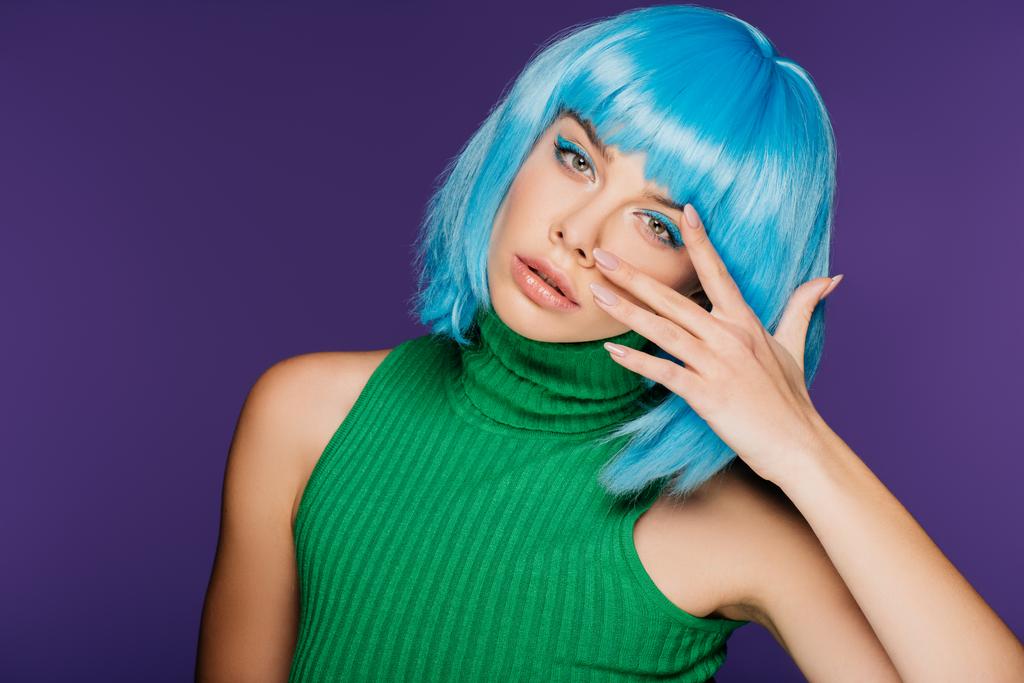 schöne Mädchen mit blauen Haaren gestikuliert und posiert isoliert auf lila - Foto, Bild