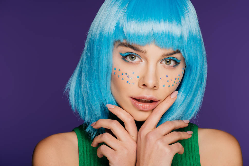 Sexy mladá žena s modrou parukou a hvězdy na tváři, izolované na fialová - Fotografie, Obrázek